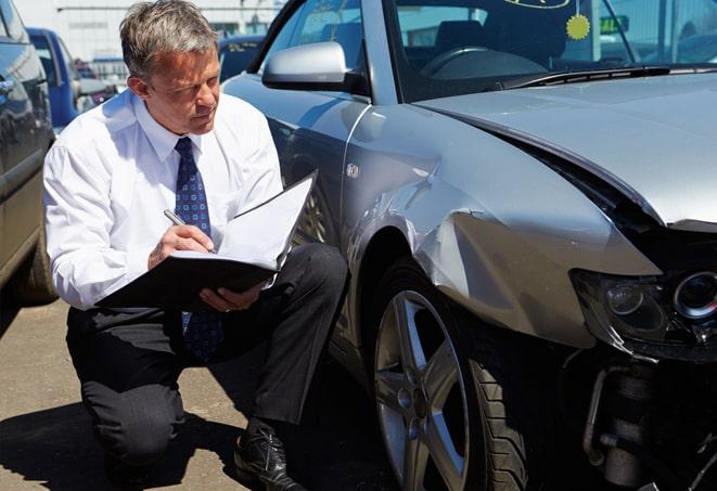 gray sedan parked in front of a car insurance office